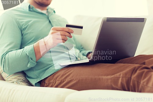 Image of close up of man with laptop and credit card