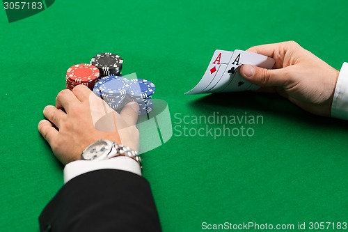 Image of poker player with cards and chips at casino