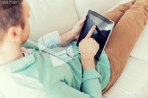 Image of close up of man with tablet pc computer at home