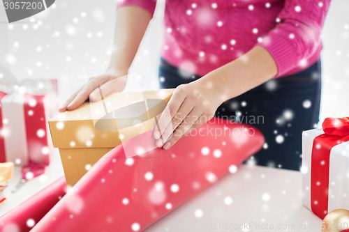 Image of close up of woman decorating christmas presents