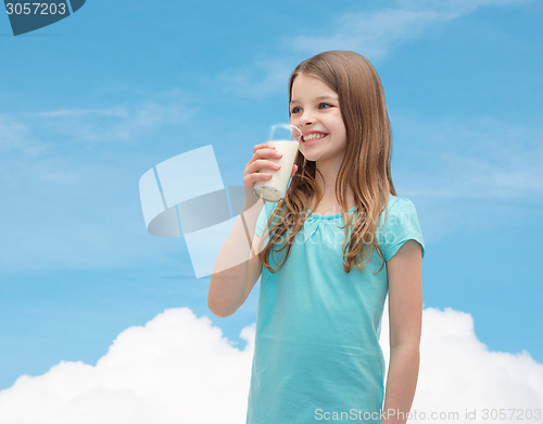 Image of smiling little girl drinking milk out of glass