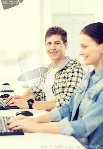 Image of smiling boy with girl in computer class at school