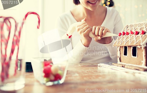 Image of close up of woman making gingerbread houses