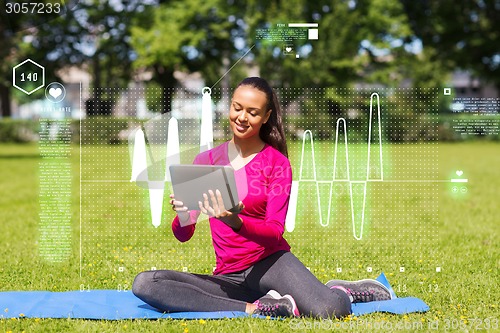 Image of smiling woman with tablet pc outdoors