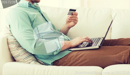 Image of close up of man with laptop and credit card