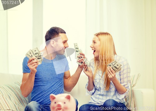 Image of couple with money and piggybank ot table at home
