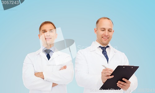 Image of smiling doctors in white coats with clipboard