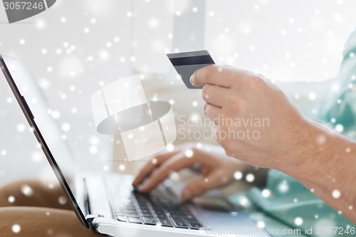 Image of close up of man with laptop and credit card