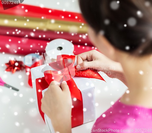 Image of close up of woman decorating christmas present