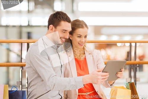 Image of couple with tablet pc and shopping bags in mall