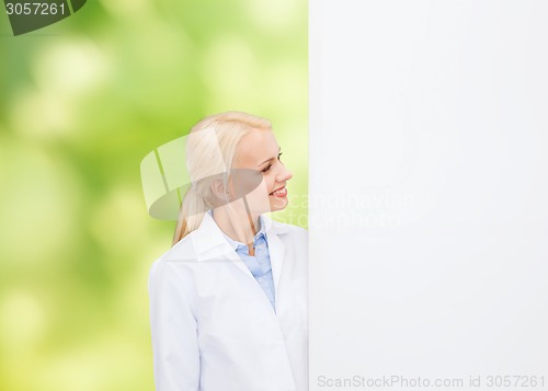 Image of smiling female doctor with white blank board