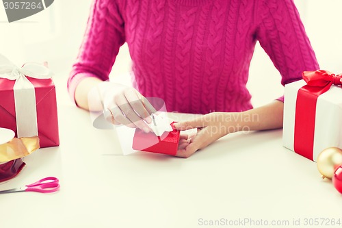 Image of close up of woman decorating christmas presents