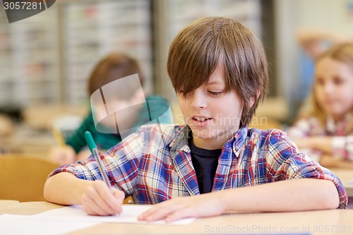 Image of group of school kids writing test in classroom