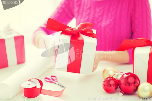 Image of close up of woman decorating christmas presents