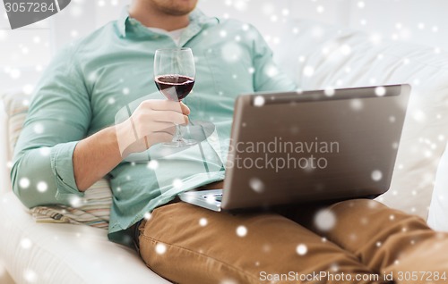 Image of close up of man with laptop and wine glass