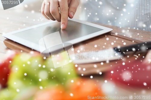 Image of closeup of man reading recipe from tablet pc