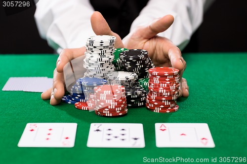 Image of poker player with cards and chips at casino