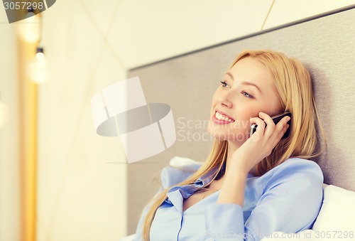 Image of happy businesswoman with smartphone in hotel room