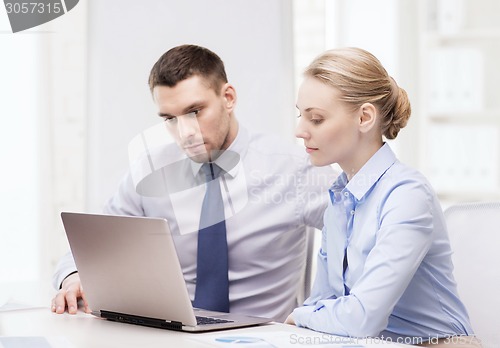 Image of business team working with laptop in office