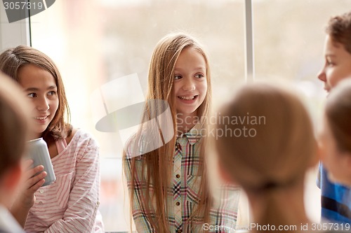 Image of group of school kids with soda cans in corridor