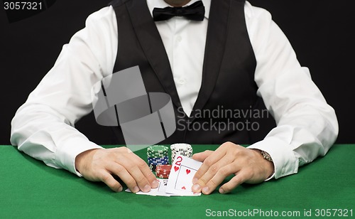 Image of poker player with cards and chips at casino