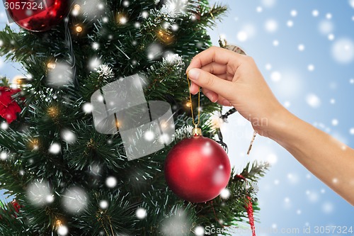 Image of close up of hand with christmas tree decoration