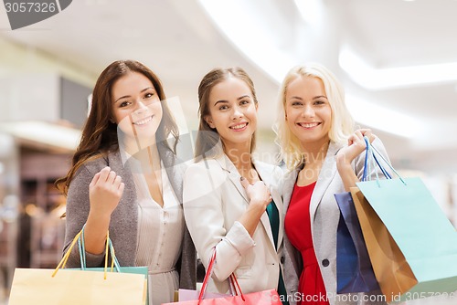 Image of happy young women with shopping bags in mall