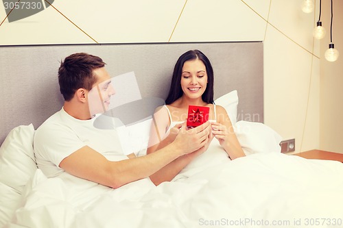 Image of man giving woman little red gift box