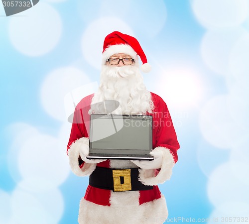 Image of man in costume of santa claus with laptop