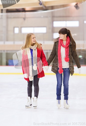 Image of happy girls friends on skating rink