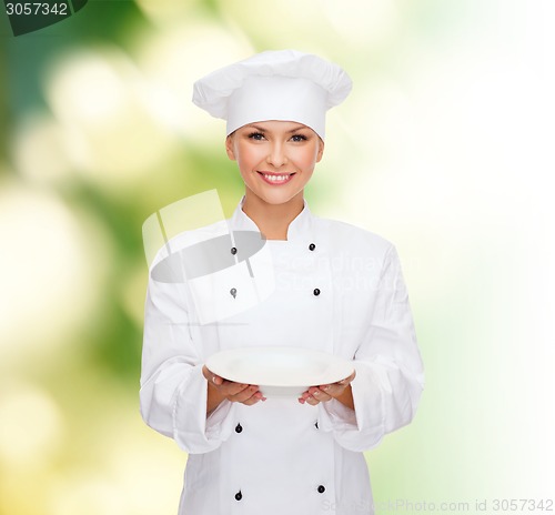 Image of smiling female chef with empty plate
