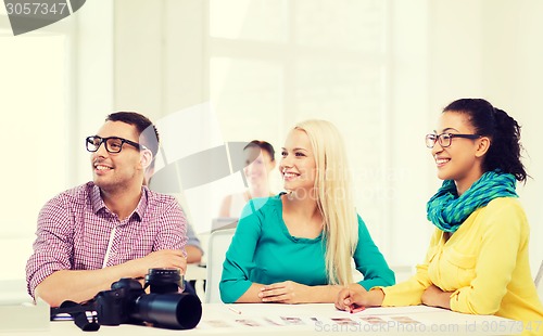 Image of smiling team with photocamera working in office