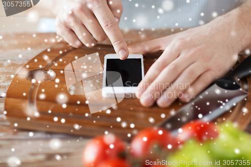 Image of close up of man reading recipe from smartphone