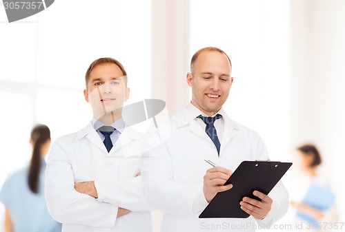 Image of smiling doctors in white coats with clipboard