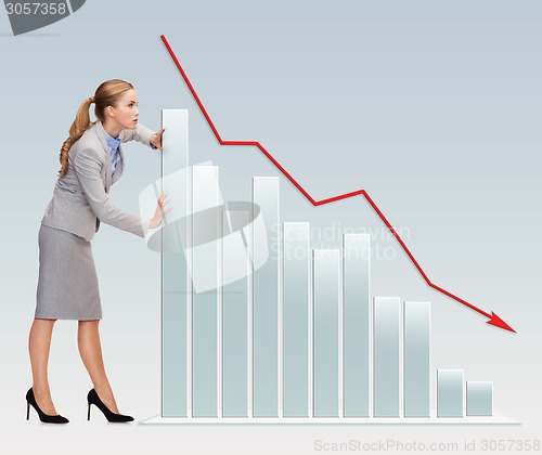 Image of busy businesswoman pushing graph falling down