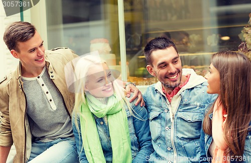 Image of group of smiling friends walking in the city