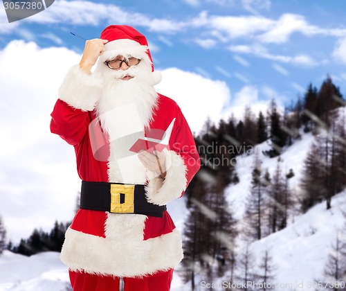 Image of man in costume of santa claus with notepad