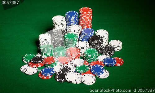 Image of close up of casino chips on green table surface