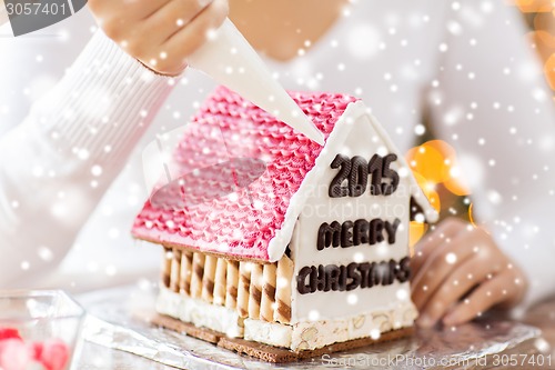 Image of close up of woman making gingerbread houses