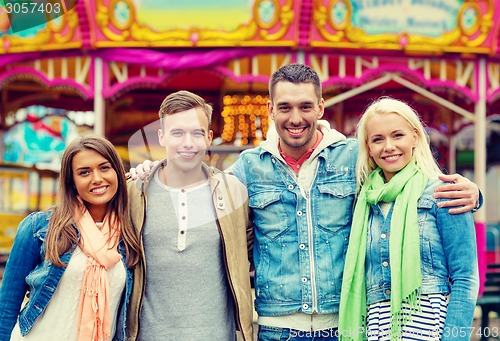 Image of group of smiling friends in amusement park