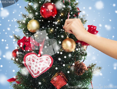 Image of close up of hand with christmas tree decoration