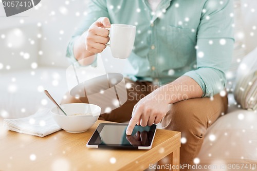 Image of close up of man with tablet pc having breakfast