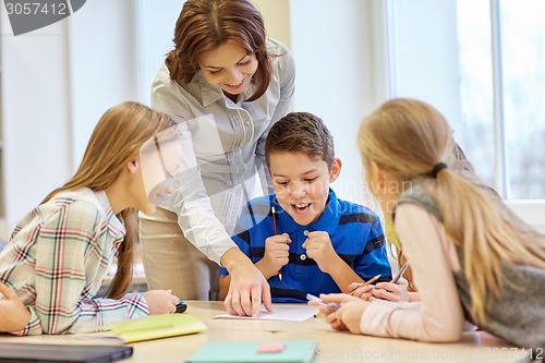 Image of group of school kids writing test in classroom