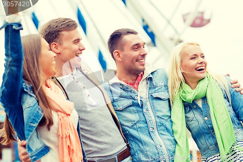 Image of group of smiling friends in amusement park