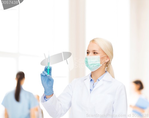 Image of doctor in mask holding syringe with injection