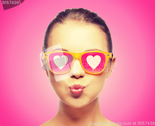 Image of girl in pink sunglasses blowing kiss