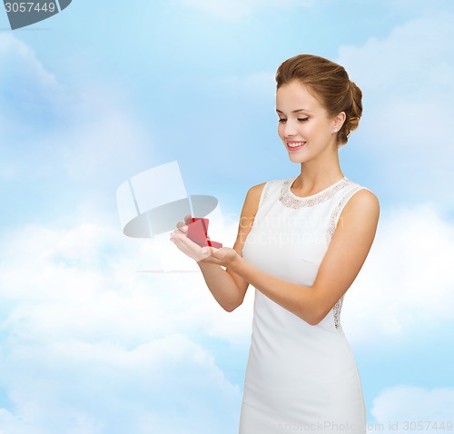 Image of smiling woman holding red gift box with ring