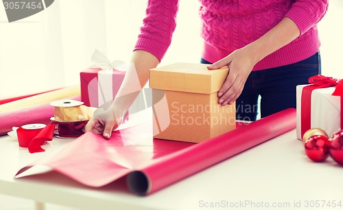 Image of close up of woman decorating christmas presents