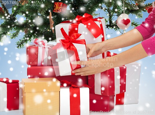Image of close up of woman with gifts and christmas tree