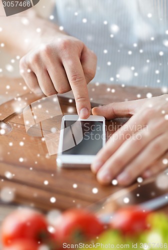 Image of closeup of man reading recipe from smartphone